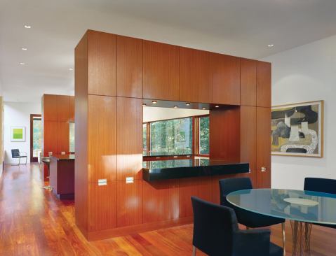 Inside, ribbon-strip African mahogany kitchen cabinets float within the light-filled space.