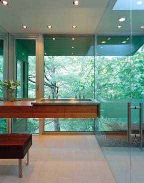 A mirrored wall opposite the shower doubles the appearance of the room’s size while also concealing pipes and wires. A large skylight over the shower balances the quality of light spilling through the diaphanous wall.