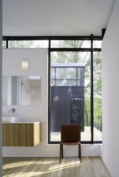 In contrast to the first floor, the second level of the home features light-colored wood floors and cabinets. The master bathroom vanity uses a limestone top.