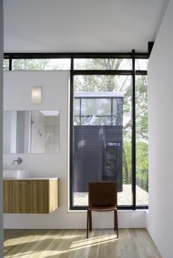In contrast to the first floor, the second level of the home features light-colored wood floors and cabinets. The master bathroom vanity uses a limestone top.

