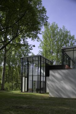 The glass volumes are oriented toward the North light, and lush tree coverage prevents heat gain.