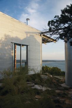 In keeping with the project's simple, elemental aesthetic, a halved steel pipe creates a gutter connecting the roof to the rainwater tank.