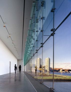 Founder's Gallery

The Founder's Gallery is a crossover space that spans the full width of the building's north face. By connecting the main east and west galleries, the linear room is woven into the choreography of the art-viewing sequence. The gallery's glass curtain wall-which stretches floor to ceiling, revealing a panoramic view of Logan Airport, Bunker Hill, and Boston's business district-is composed of cantilevered laminated glass fins with point support fittings. 