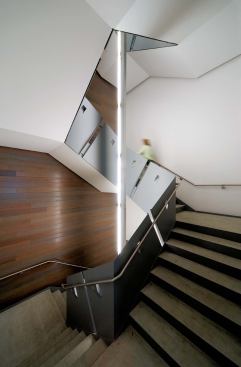 Interior Stairwell

The egress stair serves double duty as the main public stair. Shaping the stairwell is a segmented, planar surface that seems to unfurl like a roll of curling ribbon. The painted steel plates function as a guardrail and are also bent to produce rigidity for the stair stringer and handrail supports. Risers are painted steel pans containing pouredin- place concrete treads with a matte sealer. 