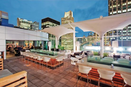 When the weather is warmer, patrons—hotel guests and locals alike—spill out onto the rooftop terrace, which features inverted umbrellas shielding bar-height countertops and perimeter tables and banquettes. Glass panels extend up to what would be ceiling height to help mitigate the high winds that can come off nearby Lake Michigan, without obstructing the view.