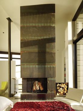 The master bedroom’s fireplace is fabricated from the same plate steel that clads sections of the exterior.