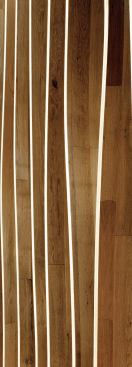 The Census Bureau building is clad in a brise soleil of wavy, laminated wood fins that are attached to a glass curtain wall, interrupted by concrete spandrels. The fins extend past the edges of the walls, creating a sinuous skin that breaks the box and enlivens the site.