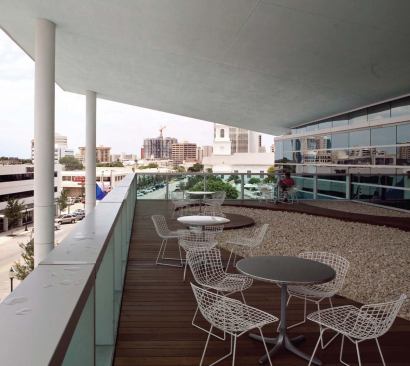 The creased roof of the Sarasota Herald Tribune headquarters is the building's signature. The design takes advantage of the local climate by integrating a deck accessible from the newsroom and by cladding the building in glass, so the sunlight can illuminate the interior during the day.


Aluminum curtain-wall system - Owen Internationa - www.owenint.com 

Specifically designed curtain-wall system - Incorporates extruded aluminum mullions and Viracon glass - Different sized panels allow for differentiation along the exterior surface of the building


Bertoia side chair - Knoll Studio - www.knoll.com 

Welded steel frame - Available in polished chrome or powder- coated paint - Cushioning options include seat, back, and complete - Greenguard certified 


Ipe wood decking - The Wood Company - www.thewoodcompany.net 

Custom deck over the entrance lobby - Solid ipe boards - Manufactured to accommodate winding gravel walk - Weather-treated to prevent rot