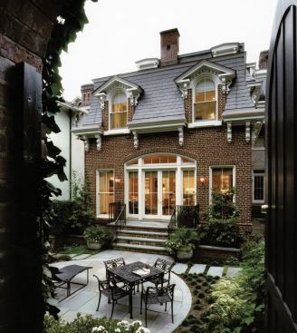 In contrast to many old-house additions that step suddenly from a small doorway to a bright room, Muse thinks about how it works its way back through the house. Here, the exterior wall's arched opening is repeated at the edge of the existing house, openin