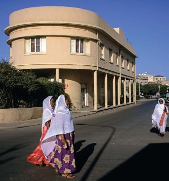 Eritrean women in traditional dress pass an apartment building, formerly the Palazzo Bahobesci, built in 1936 and recently renovated. Asmara has such a wealth of modernist buildings from the 1930s and after that locals pay them no special attention.