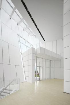 The Corian panels continue on the wall surfaces inside the clubhouse, including on the canted walls of the main lobby.