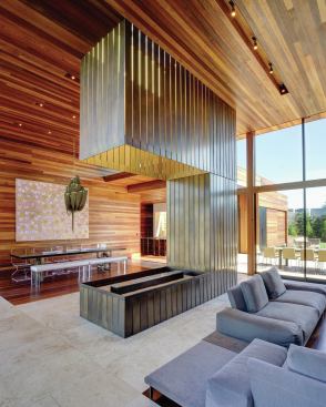 Bronze plates clad the fireplace that divides the living and dining areas. 