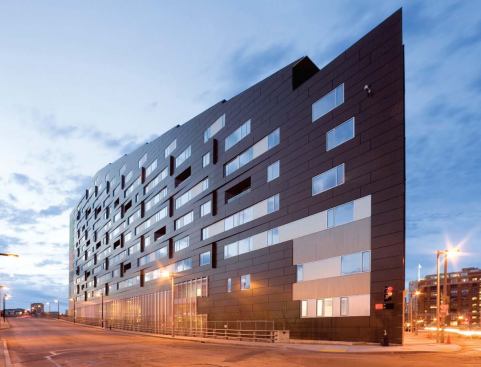 South-facing windows suggest the irregular pattern of the dwelling units inside, while projecting fins indicate the rhythm of the structural trusses that stagger from floor to floor.