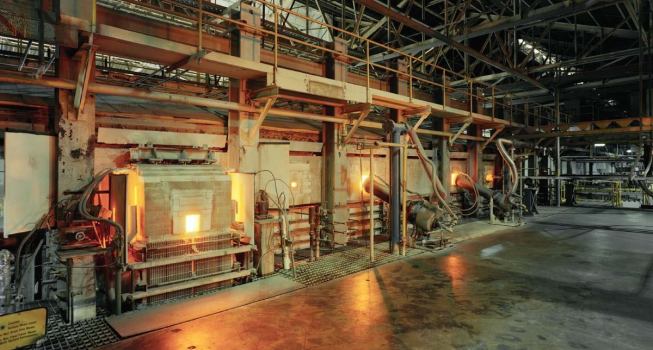 The melting process is completed in the refiner, where air bubbles are removed before the molten glass is poured onto a tin bath.