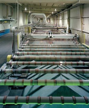 After exiting the lehr, or cooling chamber, at about 300 F, a "ribbon" of fully formed glass drops in temperature further as it moves down the cooling line. As it cools, a laser checks it for flaws.

