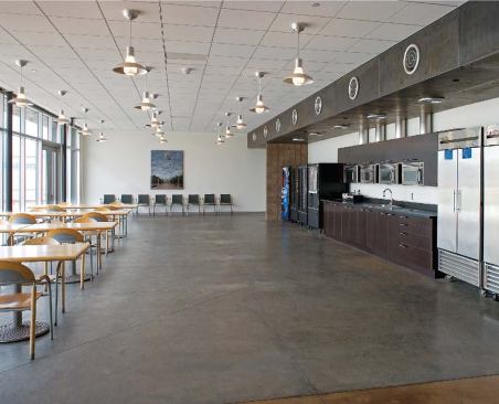 Patterned in alternating bands of stained and plain concrete, this raised pedestrian walkway leads employees safely to break rooms on the west and east sides of the warehouse.