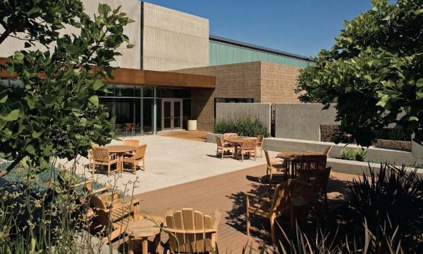 A patio with drought-resistant plantings marks the entry from the parking lot, which is bioswaled so that runo. from the asphalt percolates slowly back into the ground rather than flooding the storm drains.