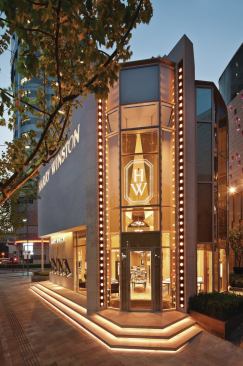 The store’s entrance, designed to read like a vertical marquee, is highlighted to each side by a row of PAR46 wide floodlamps.