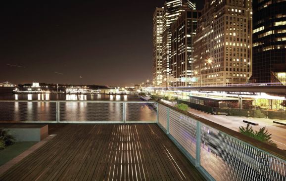 Linear fluorescents illuminate the pavilion’s soffit and roof deck, allowing light to cast a soft glow through the decking material. 
