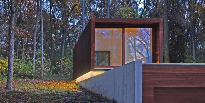 The studio volume floats atop a narrow band of continuous clerestory glazing.