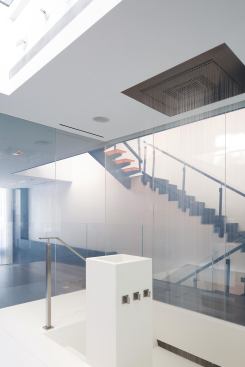 The solid-surface floor folds down, into a sunken tub/shower, and up, forming a pedestal that holds plumbing controls and a tray for soap and shampoos.