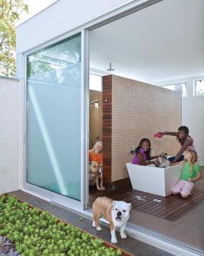 The bath opens onto a private courtyard. With four children in the family, the clients also take in rescue dogs.