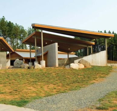 These structures' angled roofs of metal and cedar allude to the River Center's stair canopy.