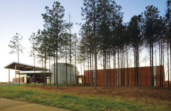 The centerpiece of the 316-acre USNWC complex is the River Center (seen from the northeast), built of concrete, cedar, and steel in a contemporary style that eschews rustic clichés. Of the concrete ellipse that forms the main entry, architect Michael Williams says, "We wanted a strong iconic element that played off of rocks we saw in all of the rivers we visited."
