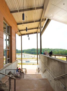 Stairs down to the channel level, canopied by perforated steel and accented with rocks on the landings.