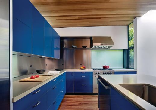 Cumaru forms the floors and ceilings of the new kitchen, adding depth and a warm layer of color to the space's white walls and marine-blue cabinetry.