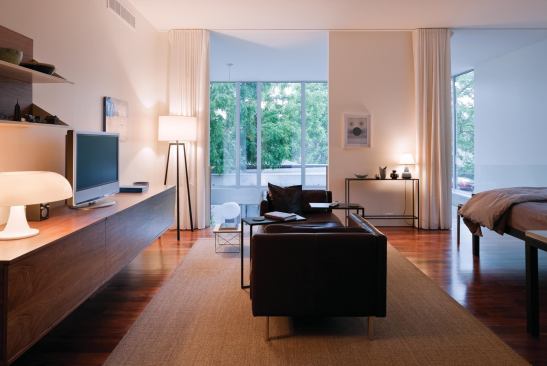 Walnut floors on the second level supply a warm hue to balance the coolness of the glass and plaster.