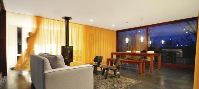 Wood-frame apertures frame views and floor to ceiling curtains provide privacy.