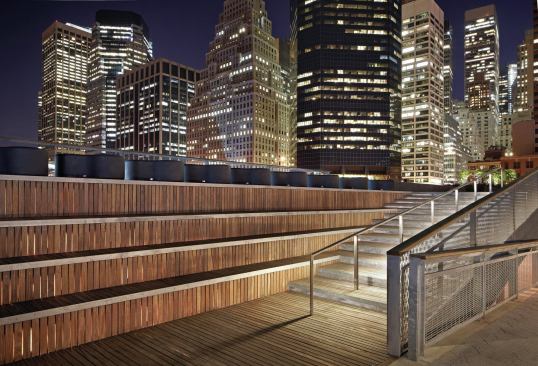 An illuminated handrail leads pedestrians to the pavilion's upper level.