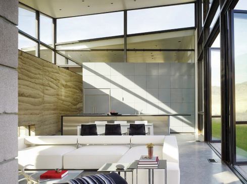 The kitchen area consists of a wall of lacquered cabinets and a stainless steel island.