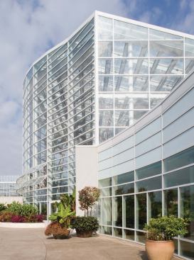 Automated vents in the lower portions of the glazed wall open near the floor of the 60-foot-tall space to capture prevailing southernly breezes. The air then climbs as it warms and exits through roof vents. As breezes pass over the glazed roof vents, a Venturi effect is created: Wind speed accelerates and draws warm air out of the interior space. Building operators continue to tweak vent-opening configurations to optimize interior conditions.