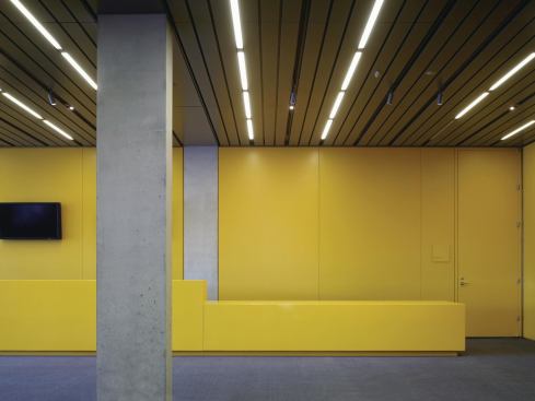 Inside the museum, the architects mix white-box galleries with public spaces differentiated by color and material. The ticketing lobby inside the new entry, for example, is dominated by bright yellow walls, serving as a contrast to the cool mirror-fritted exterior glazing.