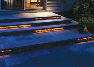 Arranged in a staggered formation, amber LEDs in 4-foot-long linear arrays provide a warm, diffuse light for the flagstone steps leading from the kitchen and family room (above). The LED strips are incorporated into the nosing detail of the step treads (below).