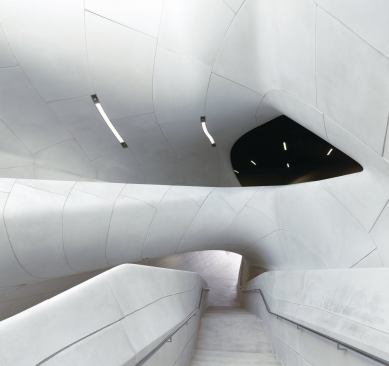 At the center of the building is a curvaceous atrium with a staircase leading to the second-level galleries. 