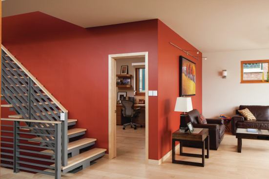 The narrow form of the house features a fairly open floor plan to allow daylight to filter through the spaces. While the heart of the home—the united dining area and kitchen—features 12-foot-tall ceilings and high windows, the living room in the home’s front southwest corner is nestled under lower ceilings for a more intimate feel. Paints from Valspar, Behr, and Martha Stewart Living, along with 5-inch-wide hacienda hard maple flooring from Muscanell Millworks add visual warmth.