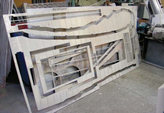 Pleats Please, Issey Miyake, Berlin - Structural ribs for the wall and frames for the table and racks were cut from 50-inch-by-100-inch sheets of half-inch aluminum plate. This photograph shows the remains of one aluminum panel after pieces have been cut on an abrasive waterjet cutting machine.