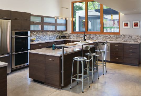 As spreading natural light was a main design goal, the fir storage cubby, also crafted by Teerlink Cabinets, separates the entryway from the dining area 

and is cut out to allow natural light to pass through.