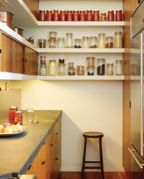 Nestling the refrigerator, storage, and pantry in the back “service area” opens the rest of the space to multiple uses.