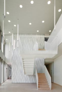 The walls in the ground-floor lobby are clad in panels that mimic the articulation of the concrete façade.