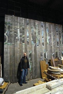 The client, Keith Pizer, with the reclaimed wood before construction. Provenance Mill Works provided salvaging services.