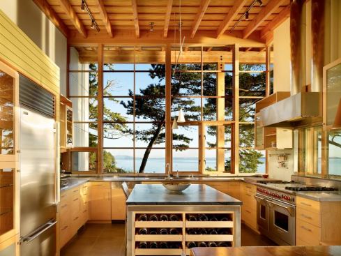 The kitchen feels expansive, thanks to well-placed windows and a warm, modern material palette.