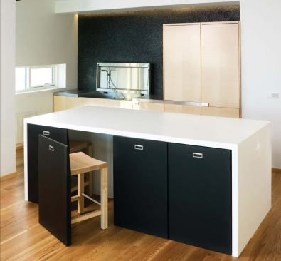 The kitchen wall is solid black lava stone. The material reflects Iceland’s volcanic topography and suggests a kind of black box theater for the owner’s live/work space.