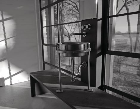 The lavatory was fabricated from salvaged agricultural equipment. The fittings were an eBay bargain. Windows are all salvaged warehouse sash.