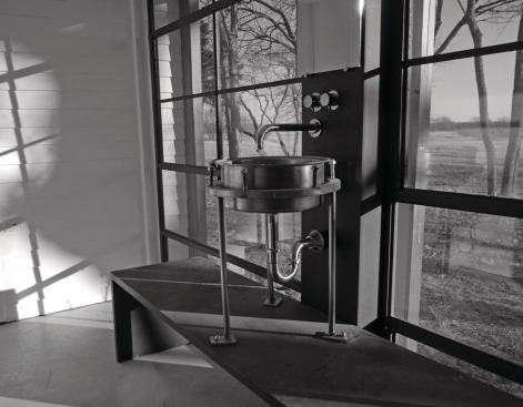 The lavatory was fabricated from salvaged agricultural equipment. The fittings were an eBay bargain. Windows are all salvaged warehouse sash.