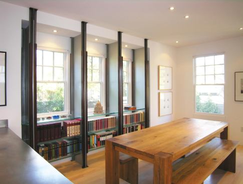 The flexible shelving system allows the owners’ extensive book collection to neatly spill over into other spaces, including the dining area.