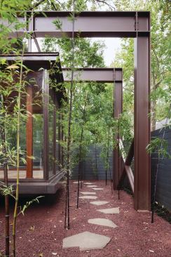 Bamboo stands and a truss canopy create a sense of journey to the entryway.